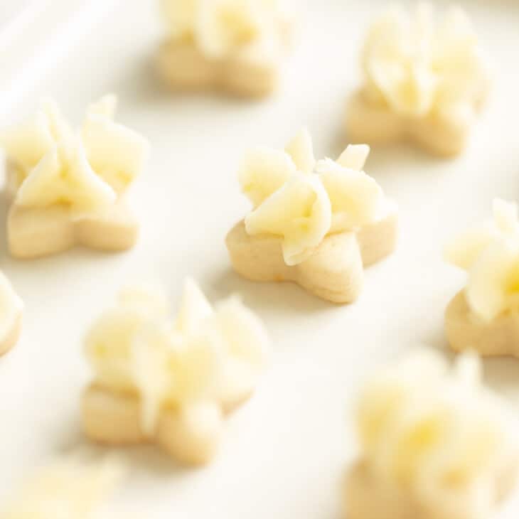 微小的花形柠檬磨砂饼干在白色盘子上。